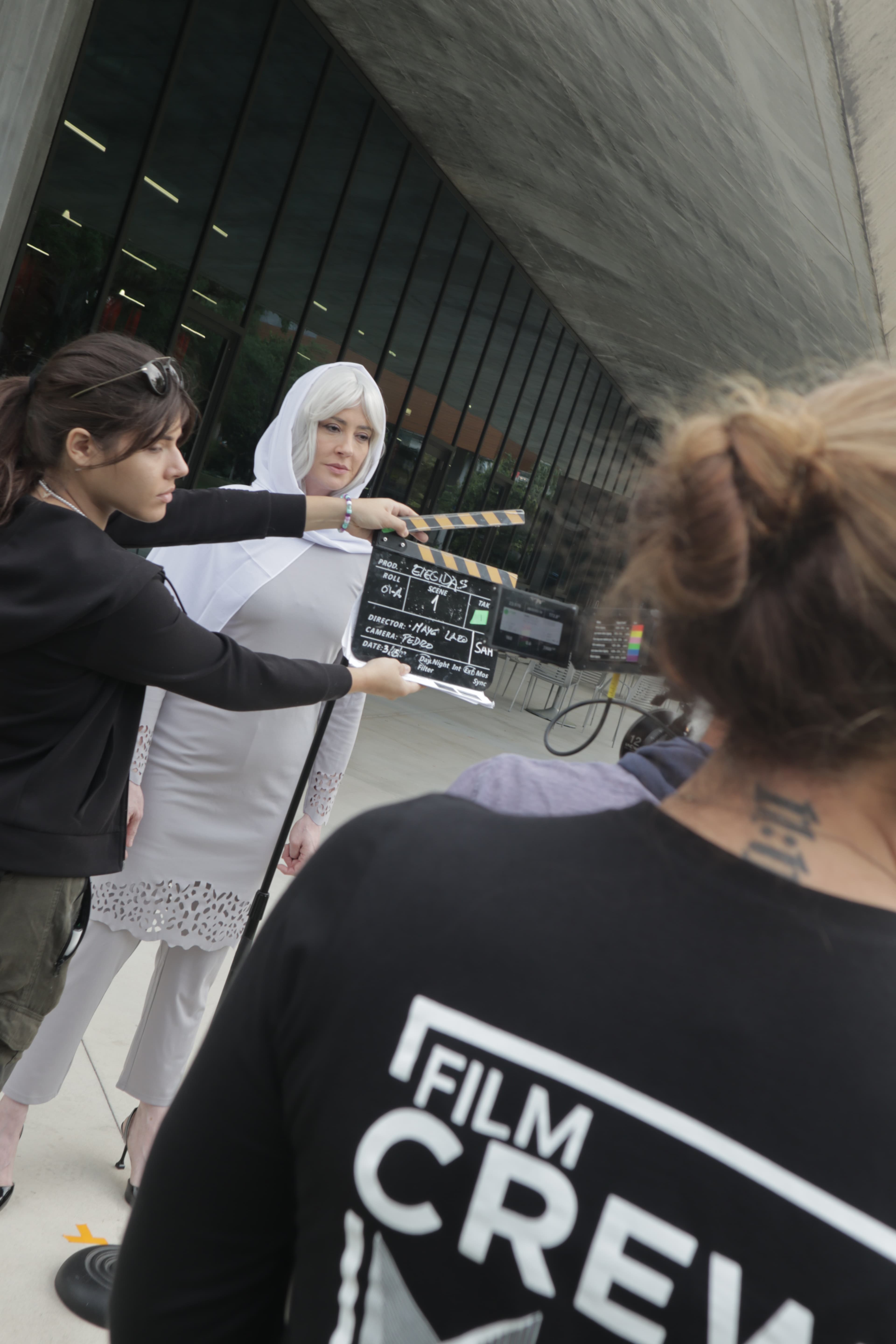Estudiantes adultos ensayando una escena durante una clase presencial de actuación, guiados por un profesor