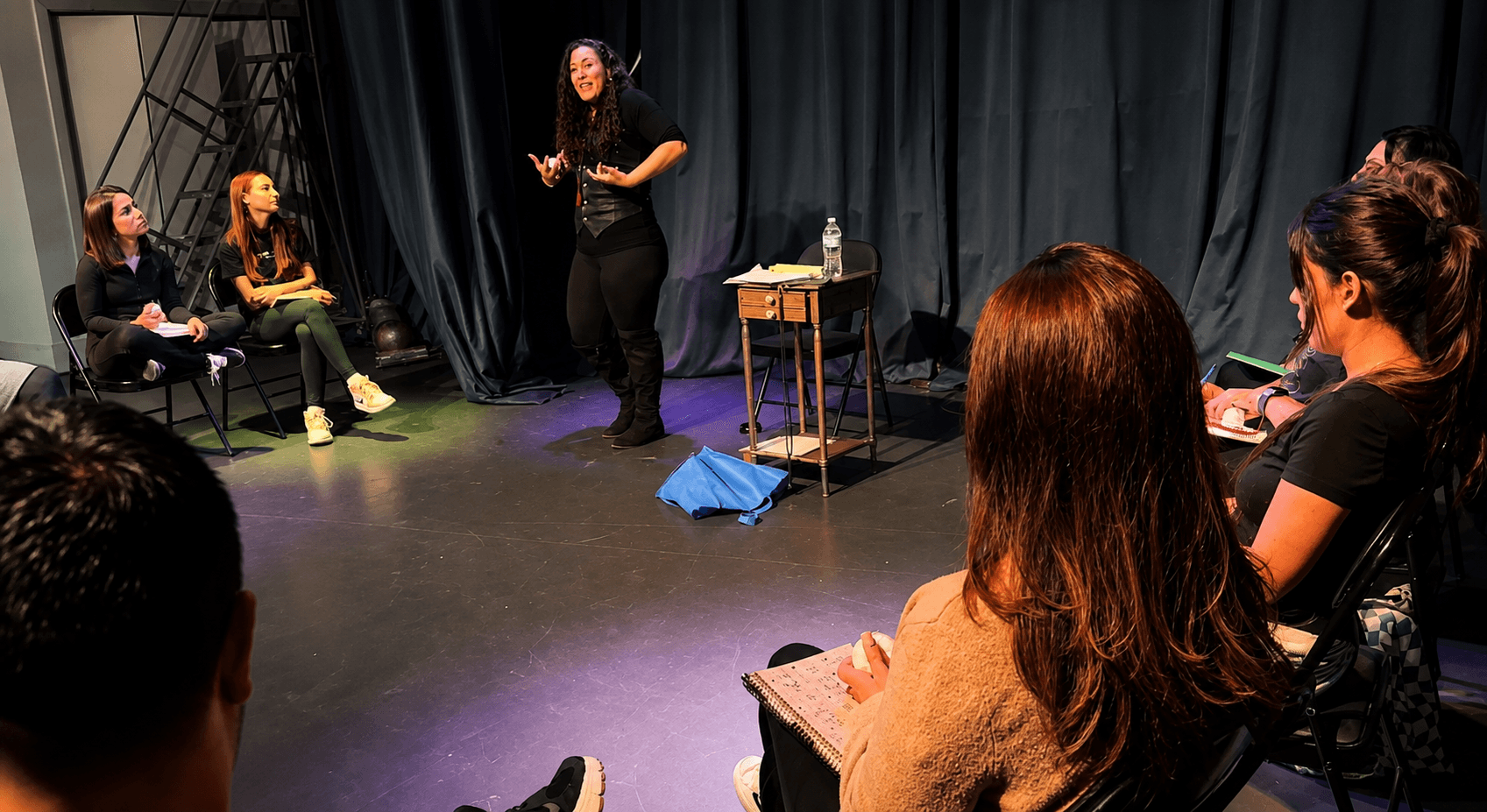 Adultos ensayando una escena con un director, guion y cámara profesional
